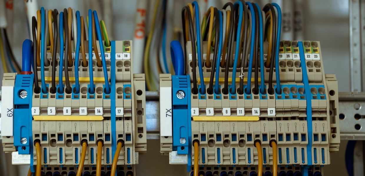 Nummerierte Reihenklemmen im Schaltschrank mit sortiert aufgelegten blauen, braunen und grün-gelben Adern